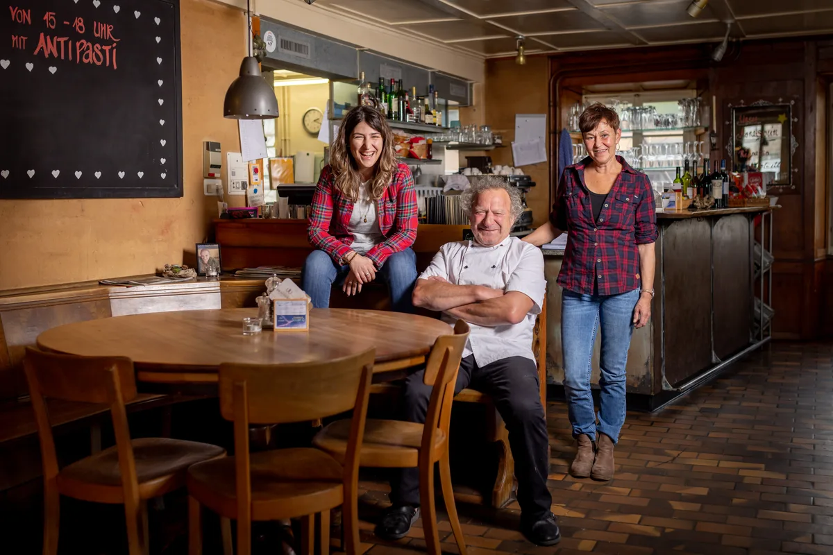 Die beiden neuen Pächterinnen Michela Cabitza (links) und Judith Glarner (rechts) haben den Übergang ohne Charly Engelhard nicht geschafft. (Archiv) 3 Personen sitzen an einem Stammtisch. Dahinter eine Theke.
